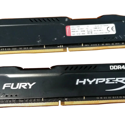 Two RAM sticks labeled 'FURY' and 'HYPERX' on a wooden surface.
