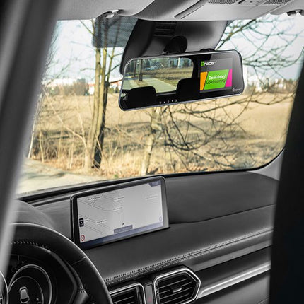 A rearview mirror car radar detector with a colorful screen display is mounted on the windshield of a vehicle, with the dashboard and steering wheel visible in the foreground.
Tracer Mensa FHD Videoregistrator 4.0D, Rezhim na parkirane