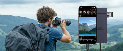 Man taking a photo of a scenic landscape with a camera and smartphone displaying the photo.